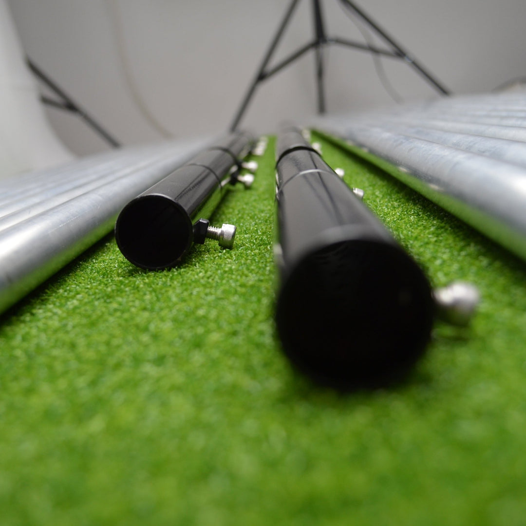 Metal poles on a green surface with a white background