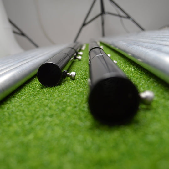 Metal poles on a green surface with a white background