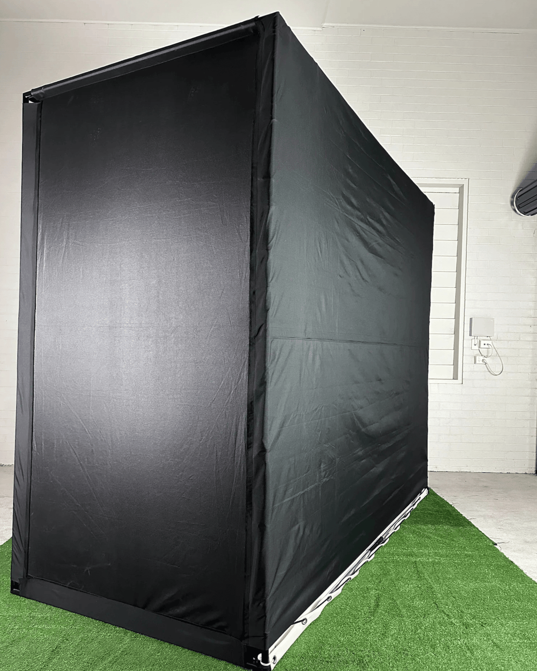 Bank and side of RooBox Diy golf enclosure on grass