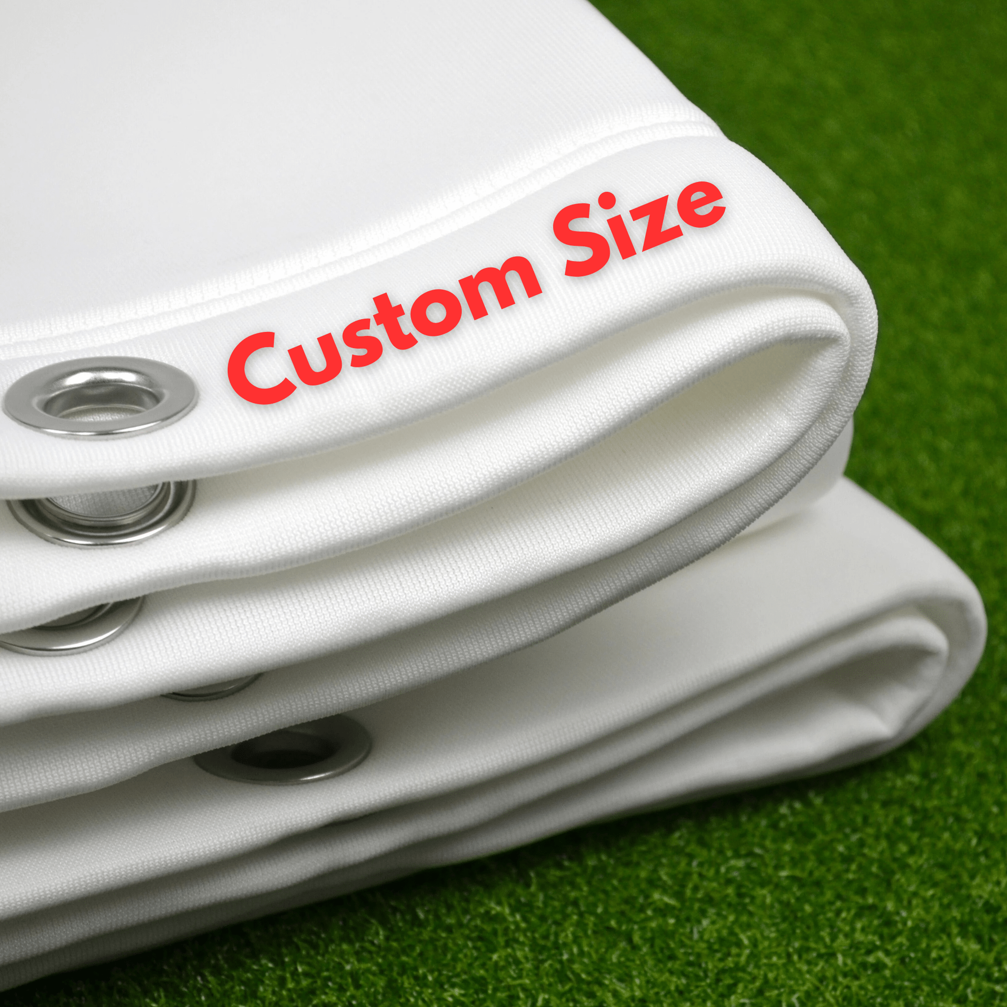 Folded white custom golf simulator impact screen with metal eyelets on green turf.
