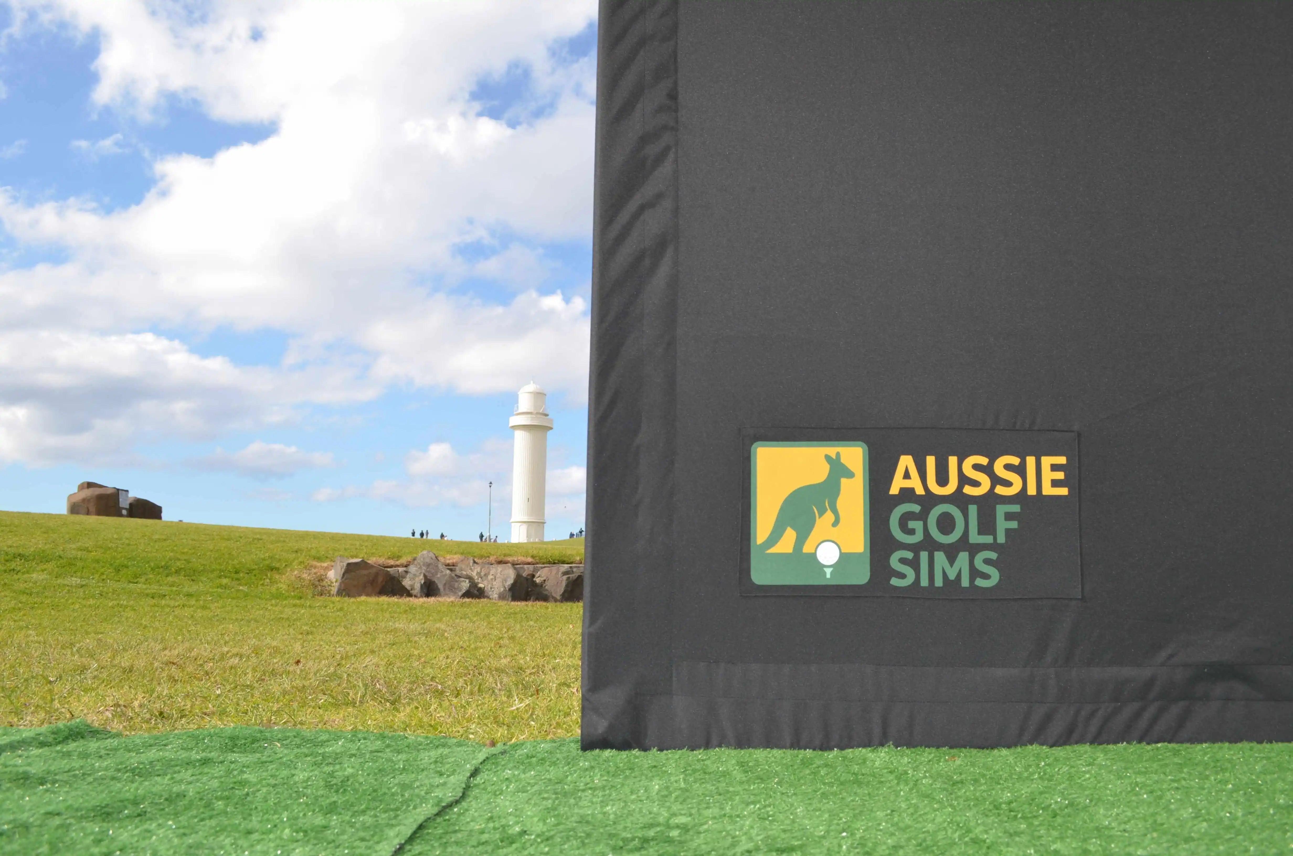 Golf simulator screen with 'Aussie Golf Sims' logo on a grassy field background