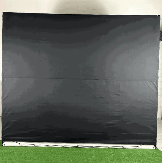 Back view of `The RooBox` golf simulator enclosure on green turf