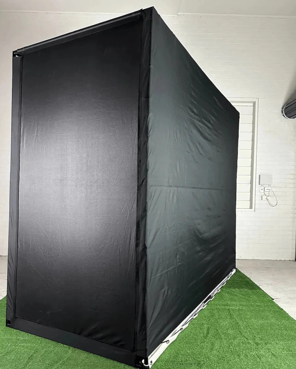 Back-right view of `The RooBox` golf simulator enclosure on green turf