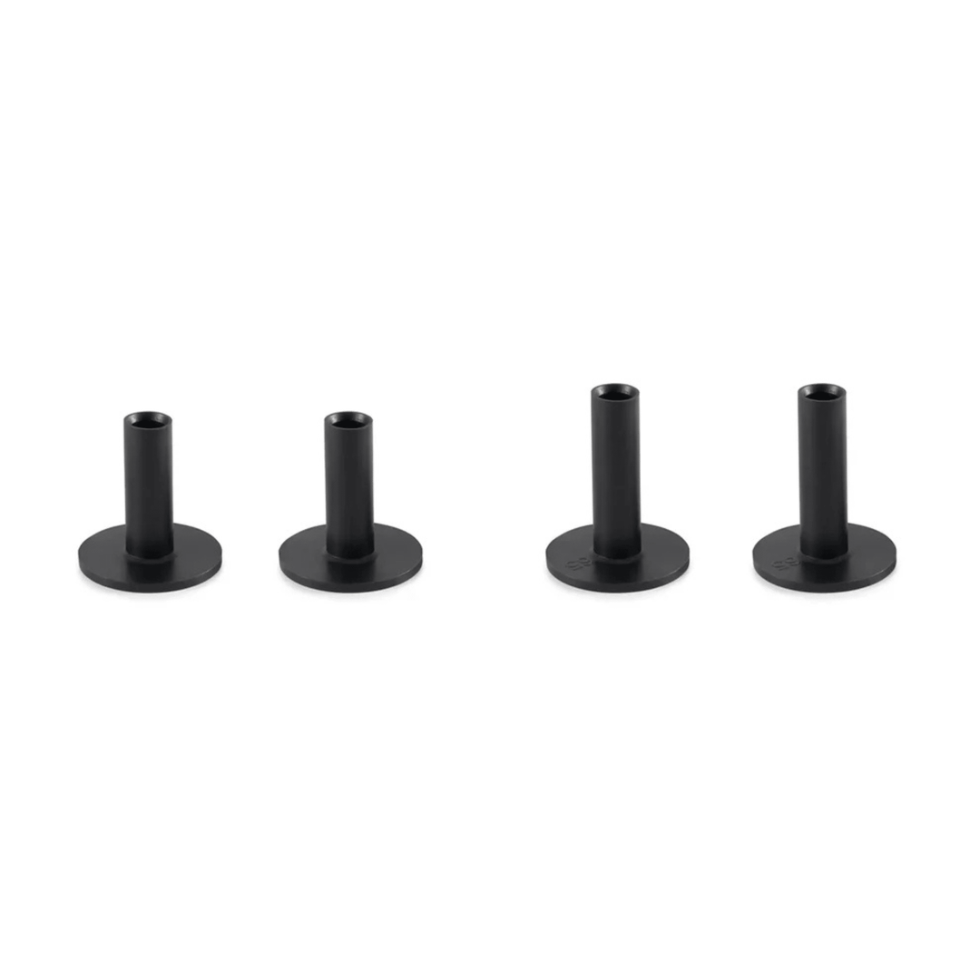 Four black, cylindrical golf tees with flat bases, varying slightly in height.