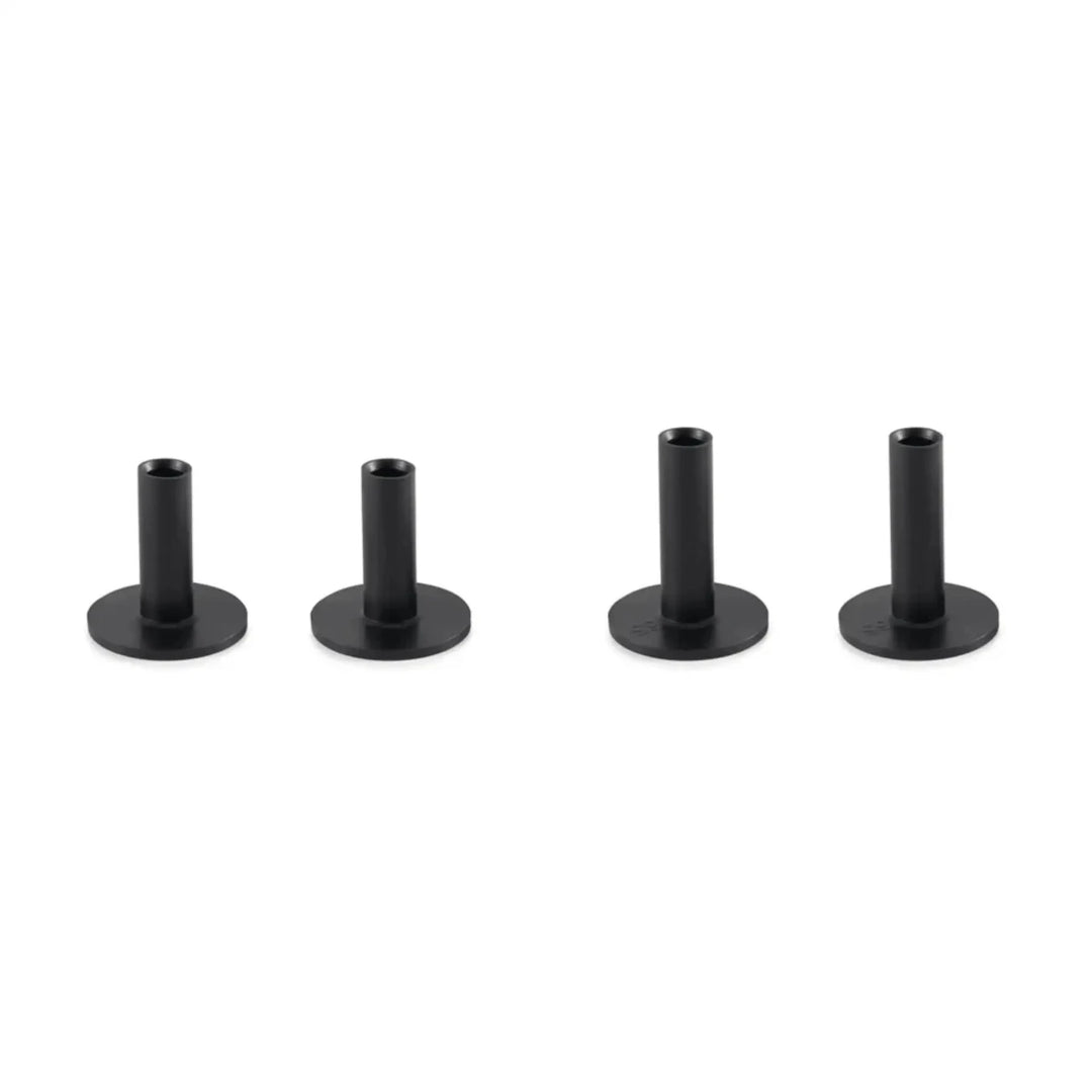 Four black, cylindrical golf tees with flat bases, varying slightly in height.