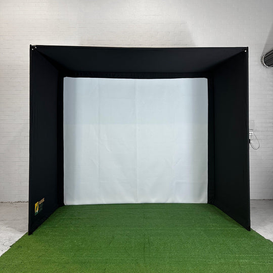 Golf simulator enclosure setup with green turf in white room