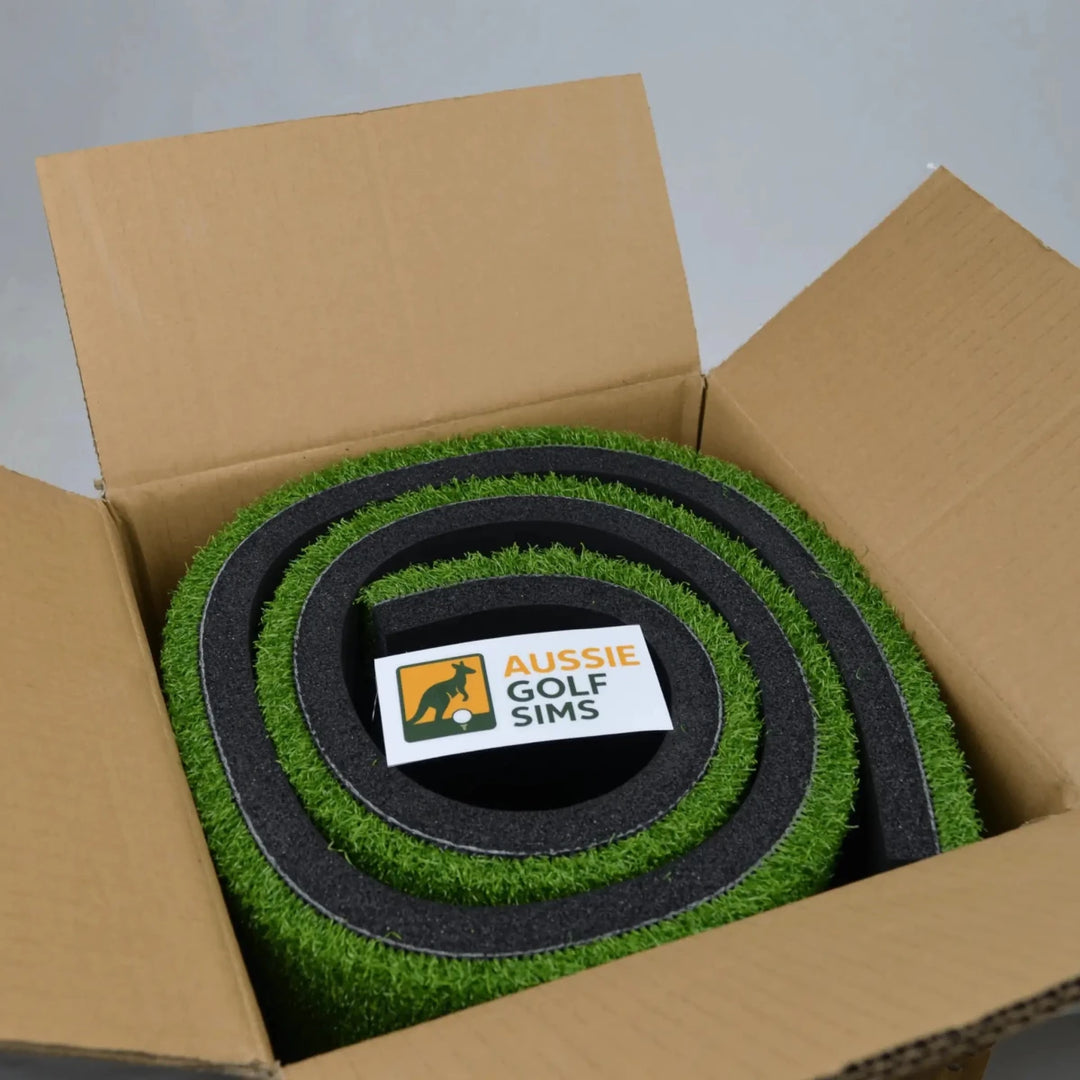 Hitting Mat with 'Aussie Golf Sims' logo in an open cardboard box.