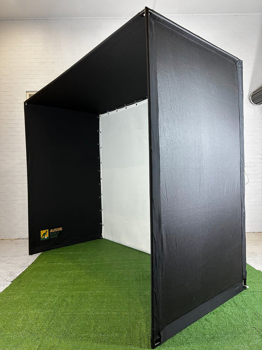 Golf Simulator enclosure side angle on grass in white walled room